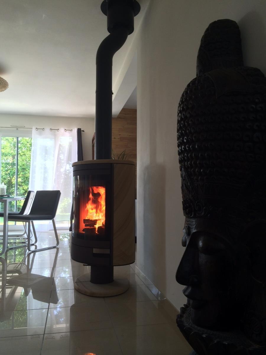 Installation d’un poêle à bois Stromboli N de la marque ROMOTOP, en pierre de grès, rotatif à 360°, permettant de diffuser la chaleur dans tous les coins de la pièce.